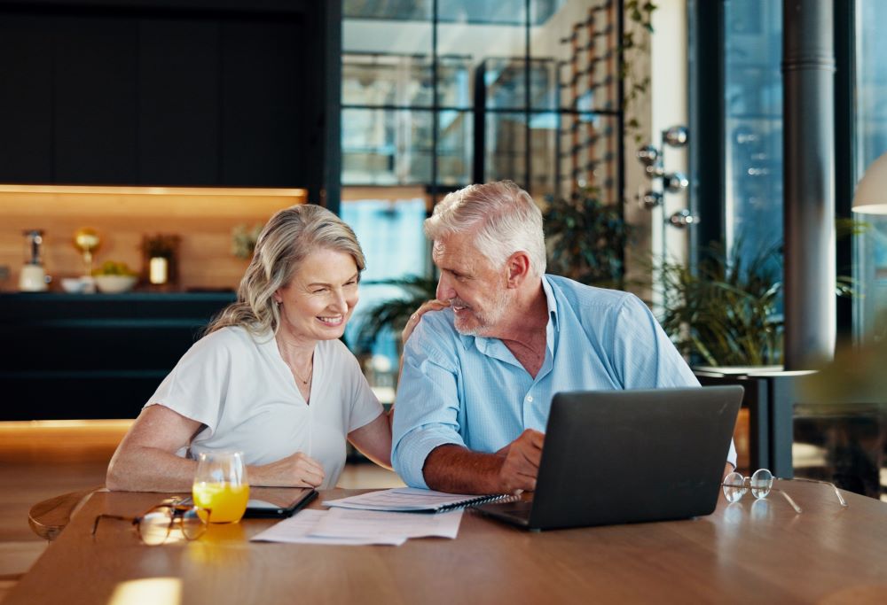 Senior couple smiling looking at the laptop